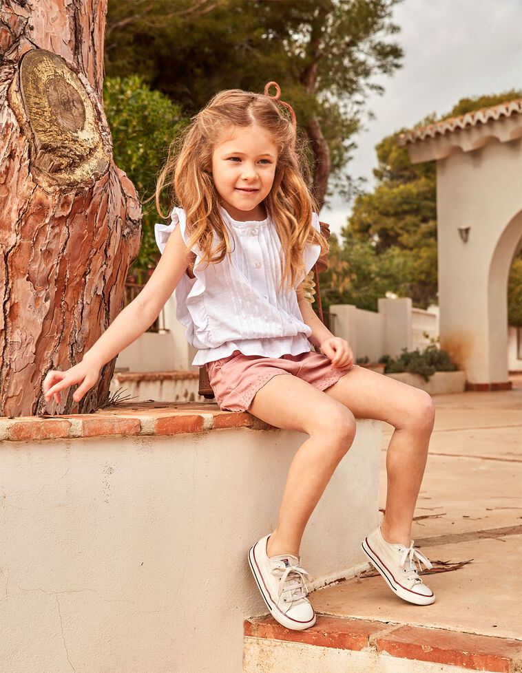 Camiseta blanca con tablitas y volante en la cintura y en sis